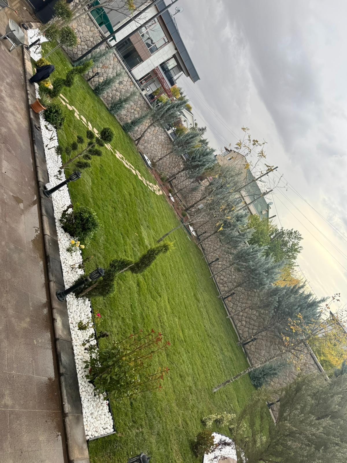 Çim alan ile çakıl yüzey arasındaki temiz kenar: düzenli bakımın görünür sonucu